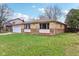 A well-maintained ranch-style home with a stone facade, green lawn, and mature trees at 4911 Carry Back Ln, Indianapolis, IN 46237