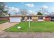 Charming ranch-style home featuring a stone facade, attached garage, and well-maintained lawn at 4911 Carry Back Ln, Indianapolis, IN 46237