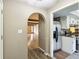 Hallway view of living room and kitchen with hardwood floors and neutral paint at 4911 Carry Back Ln, Indianapolis, IN 46237