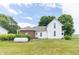 Spacious backyard featuring a well-maintained lawn, mature trees, and a white and brick home exterior at 6045 N 300 W, Greenfield, IN 46140