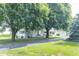 White farmhouse with mature shade trees, covered porch, and a long paved driveway at 6045 N 300 W, Greenfield, IN 46140