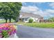 Charming two-story home with a lush front yard, beautiful flowers, and a welcoming driveway for a picturesque setting at 6045 N 300 W, Greenfield, IN 46140