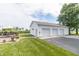 Exterior view of a three-car garage, large yard, and outdoor deck with seating at 6045 N 300 W, Greenfield, IN 46140