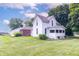 Charming white two-story farmhouse with a screened-in porch and large grassy lawn at 6045 N 300 W, Greenfield, IN 46140