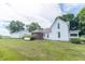 White farmhouse with a manicured lawn and a view of the house and garage at 6045 N 300 W, Greenfield, IN 46140