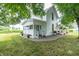 Charming white farmhouse with covered front porch, stone surround, and mature trees at 6045 N 300 W, Greenfield, IN 46140