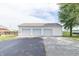 Three-car detached garage with white siding and a spacious driveway with gravel side at 6045 N 300 W, Greenfield, IN 46140