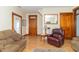 Spacious living room featuring wood trim, hardwood floors, a comfortable sofa, and a classic leather chair at 6045 N 300 W, Greenfield, IN 46140