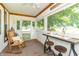 Relaxing screened porch with rocking chair, bistro table, and scenic views of the surrounding landscape at 6045 N 300 W, Greenfield, IN 46140