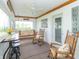 Charming screened porch with rocking chairs, swing, ceiling fan, and scenic views of the countryside at 6045 N 300 W, Greenfield, IN 46140
