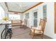 Charming screened porch with rocking chairs, swing, ceiling fan, and scenic views of the countryside at 6045 N 300 W, Greenfield, IN 46140