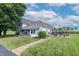 Expansive front yard with lush lawn, stone pathway, and a two-story home with a welcoming porch, exuding classic charm at 6045 N 300 W, Greenfield, IN 46140