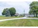 Expansive green lawn with mature trees and outbuildings on a well-maintained property at 6045 N 300 W, Greenfield, IN 46140