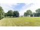 Expansive green lawn with mature trees and a view of outbuildings at 6045 N 300 W, Greenfield, IN 46140
