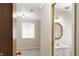 Bathroom connected to the bedroom with white sink and vanity and an illuminated light fixture at 625 Mulberry St, Zionsville, IN 46077