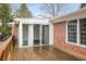 Large wooden deck with access to a brick patio and sliding door entrance to sunroom at 625 Mulberry St, Zionsville, IN 46077