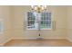 Bright dining room with large window, parquet floors, and classic chandelier at 625 Mulberry St, Zionsville, IN 46077