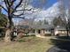 Brick home with mature trees on a sunny day, showcasing its idyllic setting at 625 Mulberry St, Zionsville, IN 46077