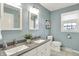 Bathroom with double sinks, modern fixtures, and light blue walls at 6537 Grosvenor Pl, Indianapolis, IN 46220