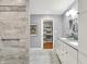 Bright bathroom with double vanity, tiled shower, and walk-in closet access at 6537 Grosvenor Pl, Indianapolis, IN 46220