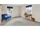 Bedroom with two windows, a blue sitting chair, and a wooden desk at 6537 Grosvenor Pl, Indianapolis, IN 46220