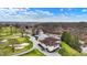Aerial of the clubhouse, tennis courts and driving range, with beautiful landscaping and a blue sky at 6537 Grosvenor Pl, Indianapolis, IN 46220