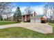 A brick two-story home with mature trees, a two-car garage, and a manicured lawn at 6537 Grosvenor Pl, Indianapolis, IN 46220