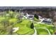Aerial view of a golf course showing the clubhouse, putting greens, and paved cart paths at 6537 Grosvenor Pl, Indianapolis, IN 46220