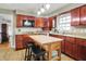 Well-lit kitchen featuring wood cabinets, granite counters, stainless steel appliances, and a central island at 6537 Grosvenor Pl, Indianapolis, IN 46220