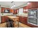 Well-lit kitchen featuring wood cabinets, granite counters, stainless steel appliances, and a central island at 6537 Grosvenor Pl, Indianapolis, IN 46220