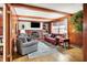 Cozy living room featuring a brick fireplace, wood-paneled walls, and comfortable seating at 6537 Grosvenor Pl, Indianapolis, IN 46220