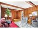 Charming living room with wood paneled walls, a vintage rug, and comfortable seating arrangement at 6537 Grosvenor Pl, Indianapolis, IN 46220