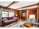 Comfortable living room with wood paneled walls, a vintage rug, and large window views at 6537 Grosvenor Pl, Indianapolis, IN 46220