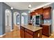 Open kitchen features a functional island, stainless steel appliances, dark wood cabinetry and hardwood flooring at 7562 Black Walnut Dr, Avon, IN 46123