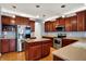 Stylish kitchen with stainless steel appliances, cherry cabinets, a center island, and hardwood floors for modern cooking at 7562 Black Walnut Dr, Avon, IN 46123