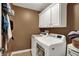 Bright laundry room with front loading washer and dryer, white cabinets, and tile flooring at 7562 Black Walnut Dr, Avon, IN 46123