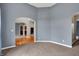 Open living space featuring carpet, gray walls, arched doorways, and views into other rooms at 7562 Black Walnut Dr, Avon, IN 46123