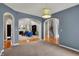 Open-concept living space with carpet flooring, arched doorways, and access to other rooms in the house at 7562 Black Walnut Dr, Avon, IN 46123