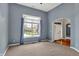 Cozy living room with carpet, large window with blue curtains, and an arched entrance at 7562 Black Walnut Dr, Avon, IN 46123