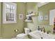 Charming powder room featuring a pedestal sink, floating shelves and soft green walls at 7562 Black Walnut Dr, Avon, IN 46123