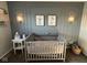 A cozy Bedroom with a grey crib, decorative wall art, and soft lighting at 7653 River Rd, Indianapolis, IN 46240