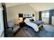 Cozy bedroom with blue accents, a comfortable chair, and ample natural light from a large window at 7653 River Rd, Indianapolis, IN 46240