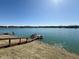 Picturesque lake view featuring a wooden dock and several boats under a clear blue sky at 7653 River Rd, Indianapolis, IN 46240