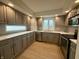 Modern kitchen equipped with stainless steel appliances, gray cabinetry, quartz countertops, and a stylish backsplash at 7653 River Rd, Indianapolis, IN 46240