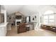 Open-concept living room with vaulted ceiling, a fireplace, floating shelves and large windows for natural light at 7653 River Rd, Indianapolis, IN 46240