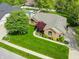 Aerial view of home showcasing manicured lawn, lush landscaping, and a charming brick exterior in a desirable location at 7732 Ashtree Dr, Indianapolis, IN 46259