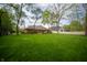 Lush backyard with mature trees featuring a stone patio and brick home for a private outdoor experience at 7732 Ashtree Dr, Indianapolis, IN 46259