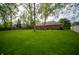 Beautiful backyard featuring green lawn, mature trees, and a well maintained exterior, creating a serene oasis at 7732 Ashtree Dr, Indianapolis, IN 46259