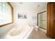 Bright bathroom featuring a large soaking tub with jets, glass block window, and separate shower stall at 7732 Ashtree Dr, Indianapolis, IN 46259
