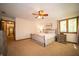 Bright bedroom with a ceiling fan, carpeted floors, and a window overlooking the yard at 7732 Ashtree Dr, Indianapolis, IN 46259